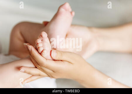 Neugeborene Füße in den Händen der Mutter. Mutter und Kind Konzept. Glückliche Familie. Stockfoto