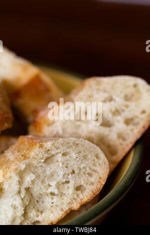 Frisches Brot schneiden und in eine Schüssel zum Abendessen Stockfoto