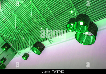 Ultra-modernen Stil in grün getönten Farben dekorative Lampen und Lampenschirme hängen an langen Seil, industriellen Decken, Interior Design. Stockfoto