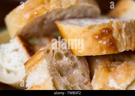 Frisches Brot schneiden und in eine Schüssel zum Abendessen Stockfoto