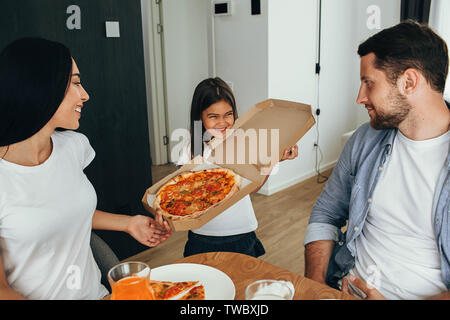 Familie Pizza. Kleines Mädchen Spaß mit Ihrer Familie Stockfoto