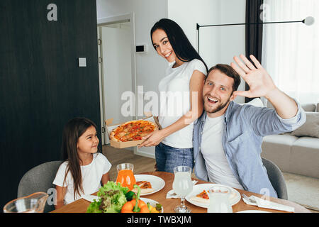 Familie Pizza. Vater, Mutter und Tochter beim Abendessen. Das Essen lecker Pizza mit Familie Stockfoto