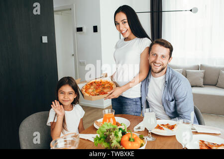 Familie Pizza. Vater, Mutter und Tochter beim Abendessen. Das Essen lecker Pizza mit Familie Stockfoto