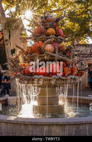Am späten Nachmittag Sonnenlicht durch den Herbst Einrichtung mit Kürbissen und cholla Cactus Holz auf einem Brunnen an der Tlaquepaque Kunst & Shopping Village glänzend Stockfoto