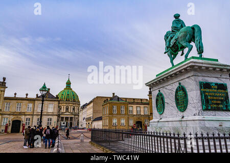 Eine Fuß Tour Gruppe außerhalb der Amalienborg Palast, mit Frederik's Kirche und einer Statue von König Frederik V. Kopenhagen, Dänemark. Januar, 2019. Stockfoto