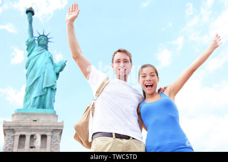 Reisen Touristen Paar an der Freiheitsstatue, New York City, USA. Multirassischen touristische Paar auf Sommer Urlaub Ferien Jubel feiern gerne. Asiatische Frau, kaukasische Mann. Stockfoto