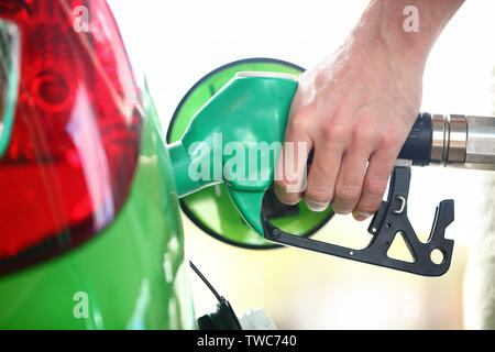 Tankstelle Pumpe. Mann füll Benzin in Green Car holding Düse. Close Up. Stockfoto