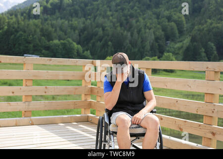 Behinderte junge Menschen im Rollstuhl in der Natur deprimiert, einsam und traurig Stockfoto