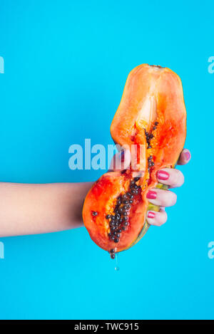 Detail einer Frau eine Papaya Hand zusammendrücken. Stockfoto