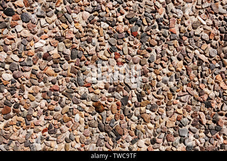Kleine Steine in betonwand als Textur Stockfoto