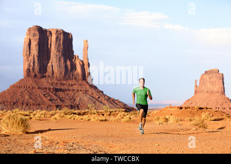 Runner. Laufender Mann sprinten im Monument Valley. Athlet runner cross country Trail Running draußen in der Natur Landschaft. Passen männlich Sport Modell in schnellen Sprint bei Geschwindigkeit, Arizona, Utah, USA. Stockfoto