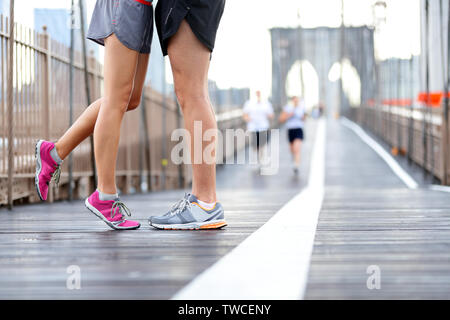 Küssen Paar läuft - Liebe sport romantischen dating Konzept. Nahaufnahme von Laufschuhen und Mädchen stehen auf Zehen Freund beim Joggen Workout Training auf der Brooklyn Bridge, New York City, USA zu küssen. Stockfoto