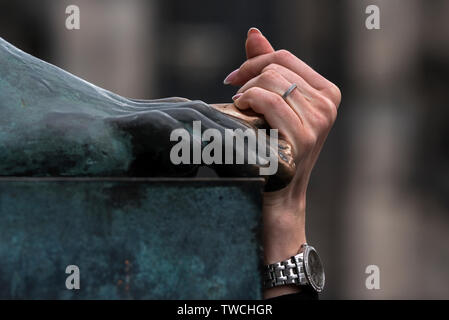 Eine weibliche Hand berührt die Zehe der David Hume statue für Glück auf der Royal Mile in der Altstadt von Edinburgh, Schottland, Großbritannien. Stockfoto