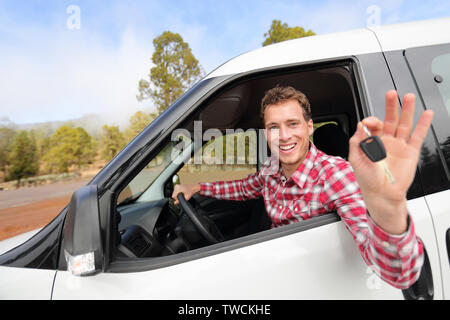 Neue Autos - Mann Auto anzeigen Autoschlüssel gerne Kamera schaut. Männliche Fahrer auf Straße Reise in wunderschöner Landschaft Natur. Fokus auf. Stockfoto