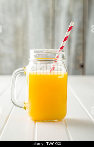 Orangensaft in Glas Krug mit swirly Stroh. Stockfoto