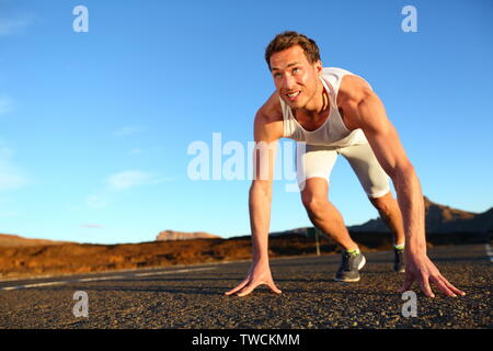 Sprinter starten Sprint-Mann laufen fertig zu sprinten. Passen männliche Läufer Athlet Training draußen auf der Straße in der wunderschönen Berglandschaft der Natur. Stockfoto