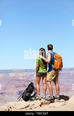 Wanderer im Grand Canyon - Wandern auf der Suche nach Anzeigen. Wanderer Mann und Frau genießen Blick auf Natur Landschaft Rucksäcke tragen. Junges Paar entspannend nach der Wanderung im Grand Canyon, Arizona, USA Stockfoto