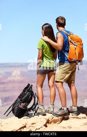 Menschen wandern - Wanderer im Grand Canyon. Wandern auf der Suche genießen Blick auf Natur Landschaft Rucksäcke tragen. Junger Mann und Frau Wanderer entspannend nach der Wanderung im Grand Canyon, Arizona, USA Stockfoto