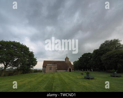 Harty, Kent, Großbritannien. Juni, 2019 19. UK Wetter: Sturm Wolken über Harty Kirche in Harty, Kent. Credit: James Bell/Alamy leben Nachrichten Stockfoto