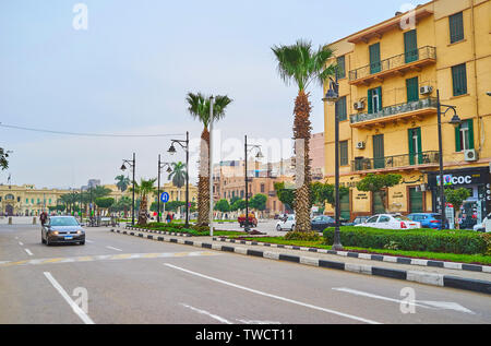 Kairo, Ägypten, 22. Dezember 2017: Zu Fuß El Tahrir Avenue mit Blick auf schlanken Palmen, Geschäften, Wohnhäusern und Abdeen Palace in El-Gomhore Stockfoto