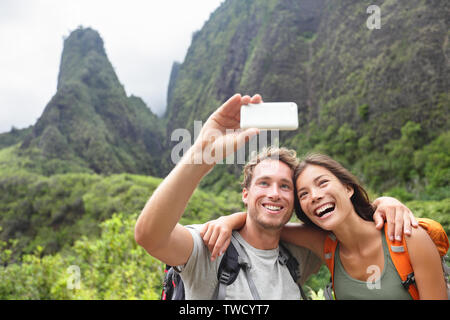 Paar unter selfie Foto mit smart phone Wandern auf Hawaii. Frau und Mann Wanderer unter Foto mit smart phone Kamera. Gesunder Lebensstil von Iao Valley State Park, Wailuku, Maui, Hawaii, USA. Stockfoto