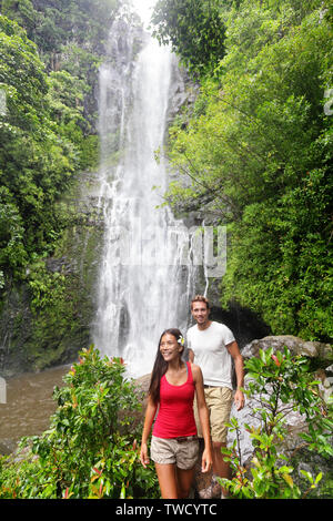 Hawaii touristische wandern Menschen. Paar von Wasserfall gerne während der Fahrt auf der Straße nach Hana auf Maui, Hawaii. Ökotourismus Konzept Bild mit glücklichen Backpackers. Interracial Asiatischen/Kaukasischen jungen Paar. Stockfoto