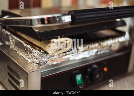 Shawarma Döner gebacken in einem elektrischen Ofen in einem Fast Food Restaurant. Pita Vorbereitung Stockfoto