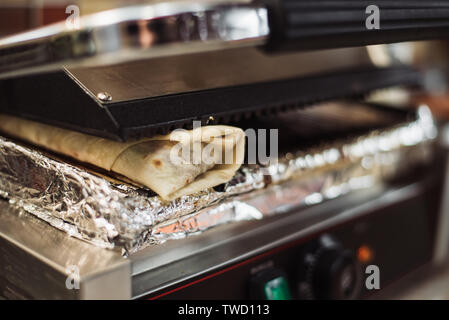 Shawarma Döner gebacken in einem elektrischen Ofen in einem Fast Food Restaurant. Pita Vorbereitung Stockfoto