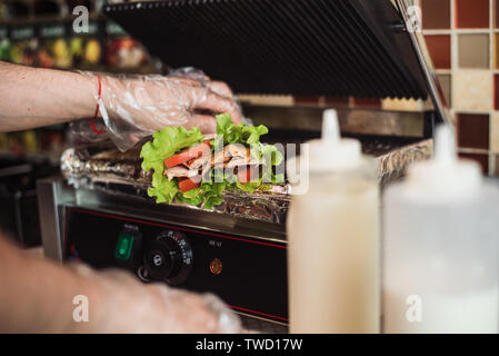 Shawarma Döner gebacken in einem elektrischen Ofen in einem Fast Food Restaurant. Kochen pita und Ciabatta auf dem Grill. Stockfoto