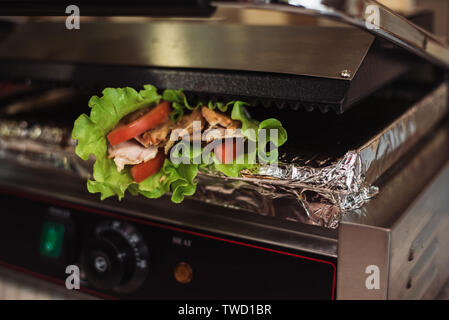 Shawarma Döner gebacken in einem elektrischen Ofen in einem Fast Food Restaurant. Kochen pita und Ciabatta auf dem Grill. Stockfoto
