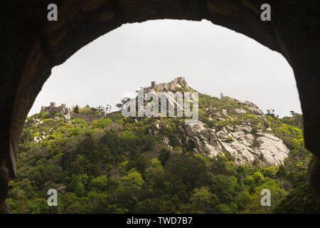 Blick auf die Burg der Mauren (Castelo Dos Mouros) durch den Bogen von der Quinta da Regaleira Teil des UNESCO-Weltkulturerbes in Sintra, Portugal Stockfoto