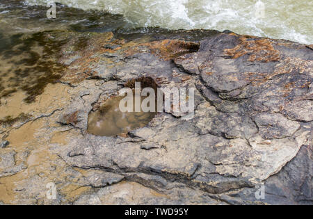 Loch in der felsigen Ufer eines Mountain River. Stockfoto