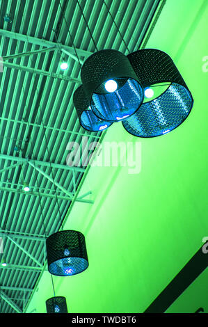 Ultra-modernen Stil in grün getönten Farben dekorative Lampen und Lampenschirme hängen an langen Seil, industriellen Decken, Innenausbau vertikale erschossen. Stockfoto