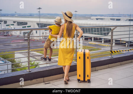 Familie am Flughafen vor dem Abflug. Mutter und Sohn warten an Bord am Abflugsteig des modernen internationalen Terminal. Reisen und fliegen mit Stockfoto