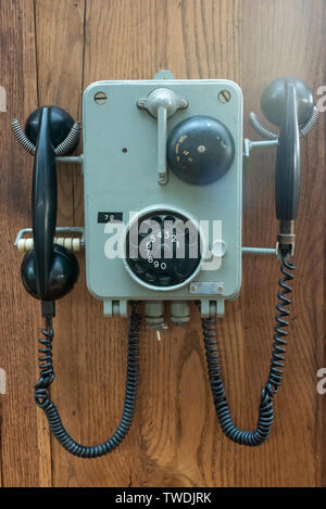 Altes Telefon an einer Holzwand Nahaufnahme Stockfoto