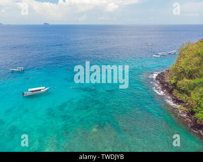 Meer Bucht mit türkisfarbenem Wasser und einem kleinen weißen Strand. Schöne Lagune und Insel vulkanischen Ursprungs mit dichtem Wald bedeckt, Ansicht von oben Stockfoto