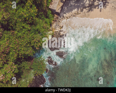 Meer Bucht mit türkisfarbenem Wasser und einem kleinen weißen Strand. Schöne Lagune und Insel vulkanischen Ursprungs mit dichtem Wald bedeckt, Ansicht von oben Stockfoto