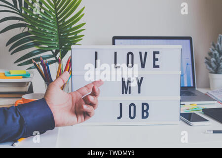 Ich liebe meinen Job Konzepte mit männlichen hand Anzeigen von Text auf Leuchtkasten auf dem Schreibtisch Tisch im Home Office.Business Motivation oder Inspiration, Leistung der menschlichen c Stockfoto