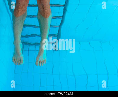 Die Beine unter Wasser in den Pool nach cuacasian Mann. Sommer. Urlaub und Sport Konzept. Stockfoto