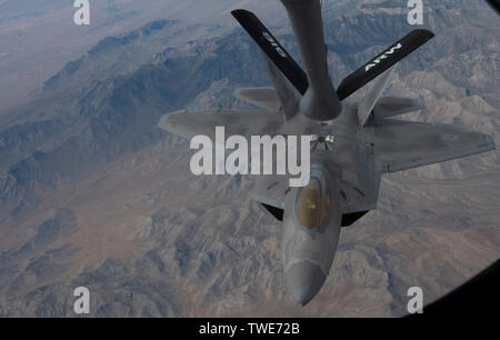 Eine F-22 Raptor fighter Jet fährt nach einem KC-135 Stratotanker der Waffen 509th Squadron bei Fairchild Air Force Base, Washington zugewiesen betankt werden, über die Nevada Test und Training Strecke Juni. 12., 2019. Die übung war Teil der US Air Force Waffen Schulen (USAFWS) Eckstein, der Höhepunkt Ihres 6-monatigen USAFWS Kurs. (U.S. Air Force Foto von Airman 1st Class Dwane R. Young) Stockfoto