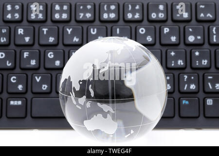 Glas Kugel Kugel mit Tastatur auf weißem Hintergrund Stockfoto