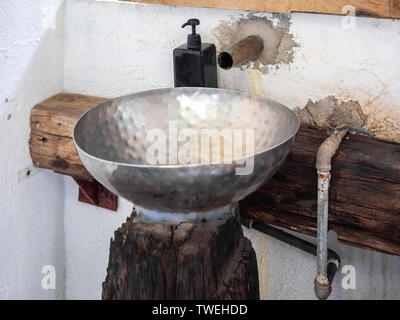 Alte vintage Edelstahl Becken Dekoration auf Weiß und Holz- Hintergrund. Stockfoto