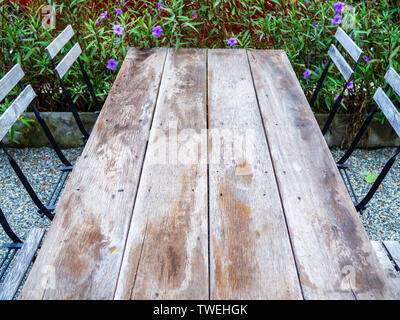 Alte Holz Esstisch und Stühle aus Holz auf Kiesboden auf Garten Hintergrund. Holztisch top Hintergrund. Stockfoto