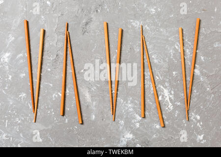 Viele Bambus Stäbchen auf schwarzem Zement Stein, Ansicht von oben mit kopieren. Viel sushi Sticks in Form des Ornaments. Stockfoto