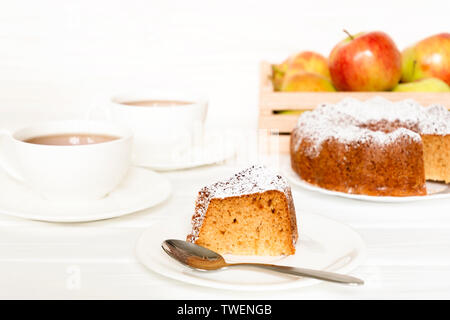 Morgen noch Leben mit Kuchen mit Puderzucker serviert Kaffee und rohe Äpfel auf weißer Tisch. Ausgewählte Schwerpunkte Stockfoto