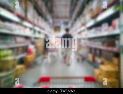 Verschwommenes Bild der Warenkorb in Gang Racks von Produkten lieferbar in Shopping Mall Stockfoto