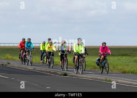 Southport, Merseyside. UK Wetter 20 Juni, 2019. Die Alterung der Bevölkerung der hell gekleidet Radfahrer nehmen Sie morgens einen Spin auf die Strandpromenade. Diese aktiven Senioren, ein Radfahren ohne Altersgruppe in Hell hi gekleidet - Sichtbarkeit bunte Mäntel & Jacken sind regelmäßige Anblick am Donnerstag als der ältere Bürger der Stadt in einem Fitness Aerobic entlang der Küstenstraße Radweg. Kredit; MediaWorldImages/AlamyLiveNews. Stockfoto