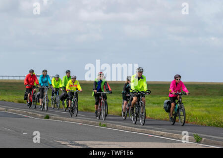Southport, Merseyside. UK Wetter 20 Juni, 2019. Die Alterung der Bevölkerung der hell gekleidet Radfahrer nehmen Sie morgens einen Spin auf die Strandpromenade. Diese aktiven Senioren, ein Radfahren ohne Altersgruppe in Hell hi gekleidet - Sichtbarkeit bunte Mäntel & Jacken sind regelmäßige Anblick am Donnerstag als der ältere Bürger der Stadt in einem Fitness Aerobic entlang der Küstenstraße Radweg. Kredit; MediaWorldImages/AlamyLiveNews. Stockfoto