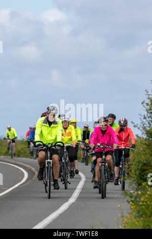 Southport, Merseyside. UK Wetter 20 Juni, 2019. Die Alterung der Bevölkerung der hell gekleidet Radfahrer nehmen Sie morgens einen Spin auf die Strandpromenade. Diese aktiven Senioren, ein Radfahren ohne Altersgruppe in Hell hi gekleidet - Sichtbarkeit bunte Mäntel & Jacken sind regelmäßige Anblick am Donnerstag als der ältere Bürger der Stadt in einem Fitness Aerobic entlang der Küstenstraße Radweg. Kredit; MediaWorldImages/AlamyLiveNews. Stockfoto