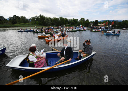 Seehausen, Deutschland. Juni, 2019 20. Die Gläubigen in der traditionellen Tracht sitzen in ihren Boote während des Corpus Christi meer Prozession am Staffelsee in Seehausen. Seit 1935 führt die Prozession von der Kirche des Dorfes auf den See. Von dort geht es mit dem Boot auf die Insel Wörth, zu den Wurzeln der Seehauser Pfarrkirche. Quelle: Angelika Warmuth/dpa/Alamy leben Nachrichten Stockfoto